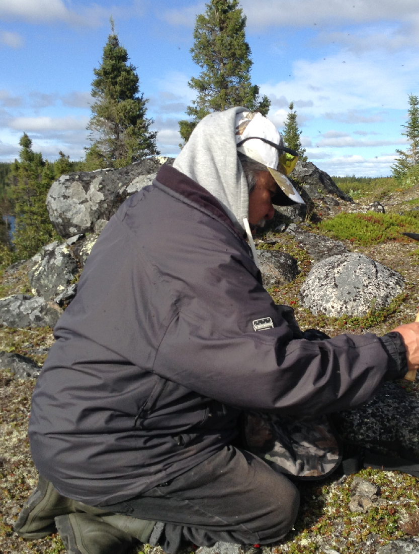 Jonas Sheshamush examining rocks on his traplines in Eeyou Istchee